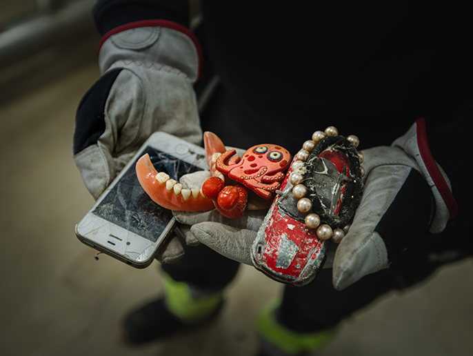 Daniel håller i föremål som kommit in till reningsverket genom avloppet – en smartphone, löständer och leksaker